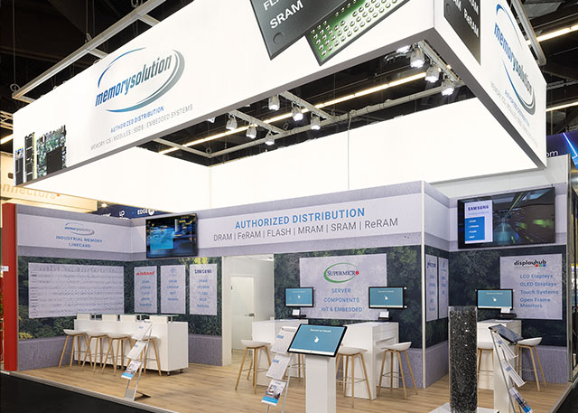 Messestand von Memorysolution mit beleuchtetem Banner, Wandgrafiken und Bildschirmen